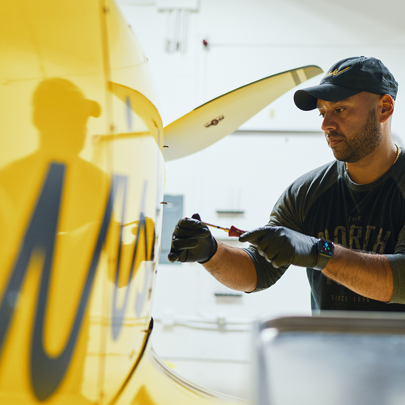 Person working on an exterior panel of the aircraft